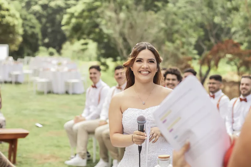 Noiva sorrindo com o microfone durante a cerimônia