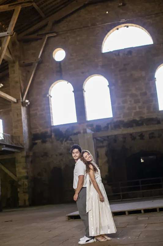Casal de mãos dadas em um salão antigo de pedra