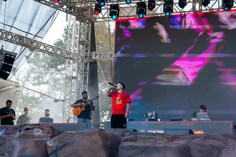 Cantor de camisa vermelha no palco com o violonista ao lado