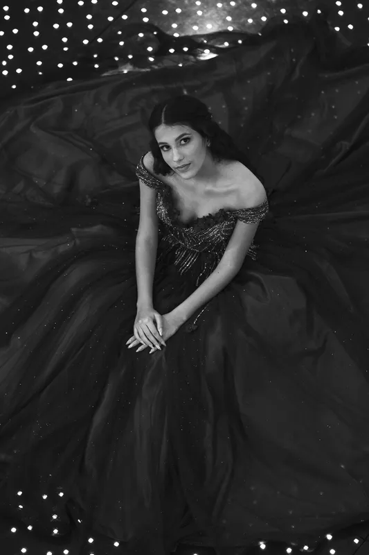 Debutante sentada com o vestido aberto entre luzinhas